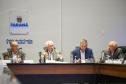 Fotografia mostra quatro homens sentados à mesa de reunião, da esquerda para a direita: Domingos Trevisan Filho (diretor-geral da SEPL), de óculos e terno marrom; Darci Piana (Vice-Governador), de cabelos brancos e terno bege, falando ao microfone; Luizão Goulart (secretário da Administração e da Previdência), de paletó azul e olhando para baixo; e um quarto participante de terno cinza. Ao fundo, na parede branca, destaca-se o brasão do Governo do Paraná e a inscrição "Gabinete de Gestão e Informações - GGI